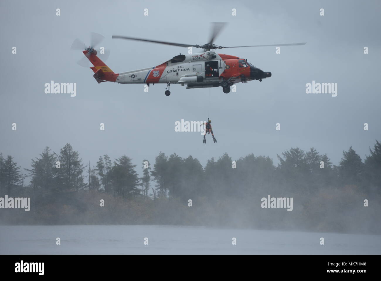Petty Officer 2a classe Giordania Gilbert, una sopravvivenza di aviazione tecnico al Coast Guard Settore Columbia River, viene abbassata da un MH-60 elicottero Jayhawk durante la ricerca e la dimostrazione di salvataggio presso gli Stati Uniti/Cina Disaster Management valuta detenute a Camp Rilea situato in Warrenton, Ore., nov. 16, 2017. Soldati di U.S. Pacifico esercito, Oregon Guardia Nazionale e la Repubblica popolare di Cina, Popolo della Esercito di Liberazione Teatro Sud Il comando ha preso parte nel XIII iterazione del cambio, che è progettato per condividere real-mondo lezioni apprese circa la fornitura di assistenza umanitaria e di soccorso in caso di catastrofe Foto Stock