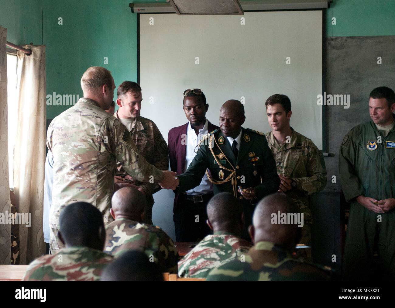 Camerunese Forze Armate Il Mag. Rene Didier Bekada, centro, vice comandante del Cameroon forze armate (scuola di ingegneria, mani fuori bandiera camerunese patch in gesto di amicizia alla cerimonia di laurea di esercizio contatore esplosivi improvvisati Device-Defeat Fase I a Douala Camerun, Novembre 17, 2017. L'esercizio, guidati da U.S. I soldati della 764th Ordnance Company (l'eliminazione degli ordigni esplosivi) fuori di Fort Carson, Colo., insegna potenzialmente salvavita competenze, incluse le modalità per il riconoscimento e lo smaltimento sicuro di IED. La minaccia di IED contatto è rilevante per le truppe camerunesi, WH Foto Stock