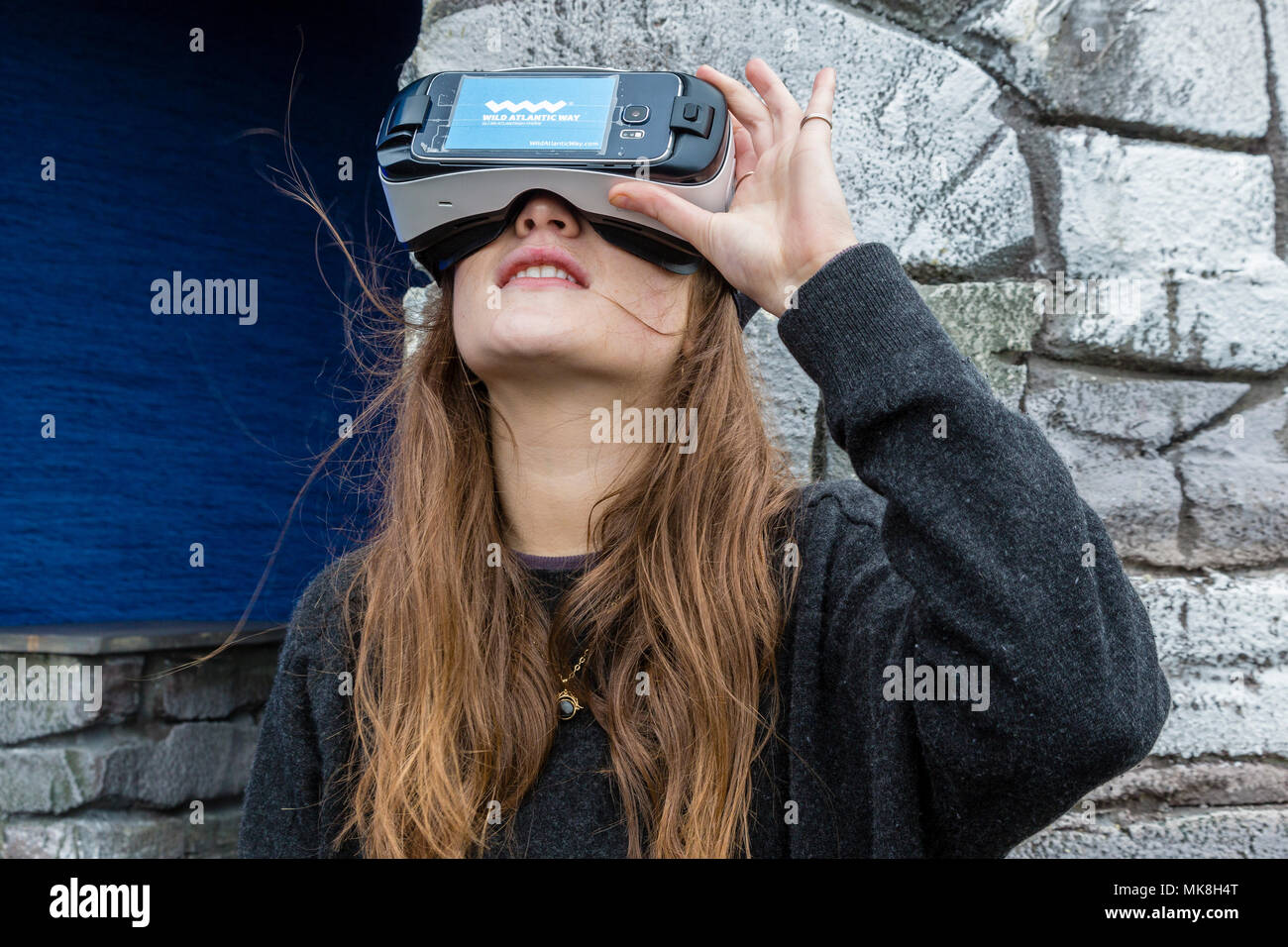 Le giovani donne che indossano le cuffie VR per visualizzare la destinazione di viaggio sull'anello di Kerry, utilizzato dall'Irish tourist board per promuovere l'Skellig Rocks Foto Stock
