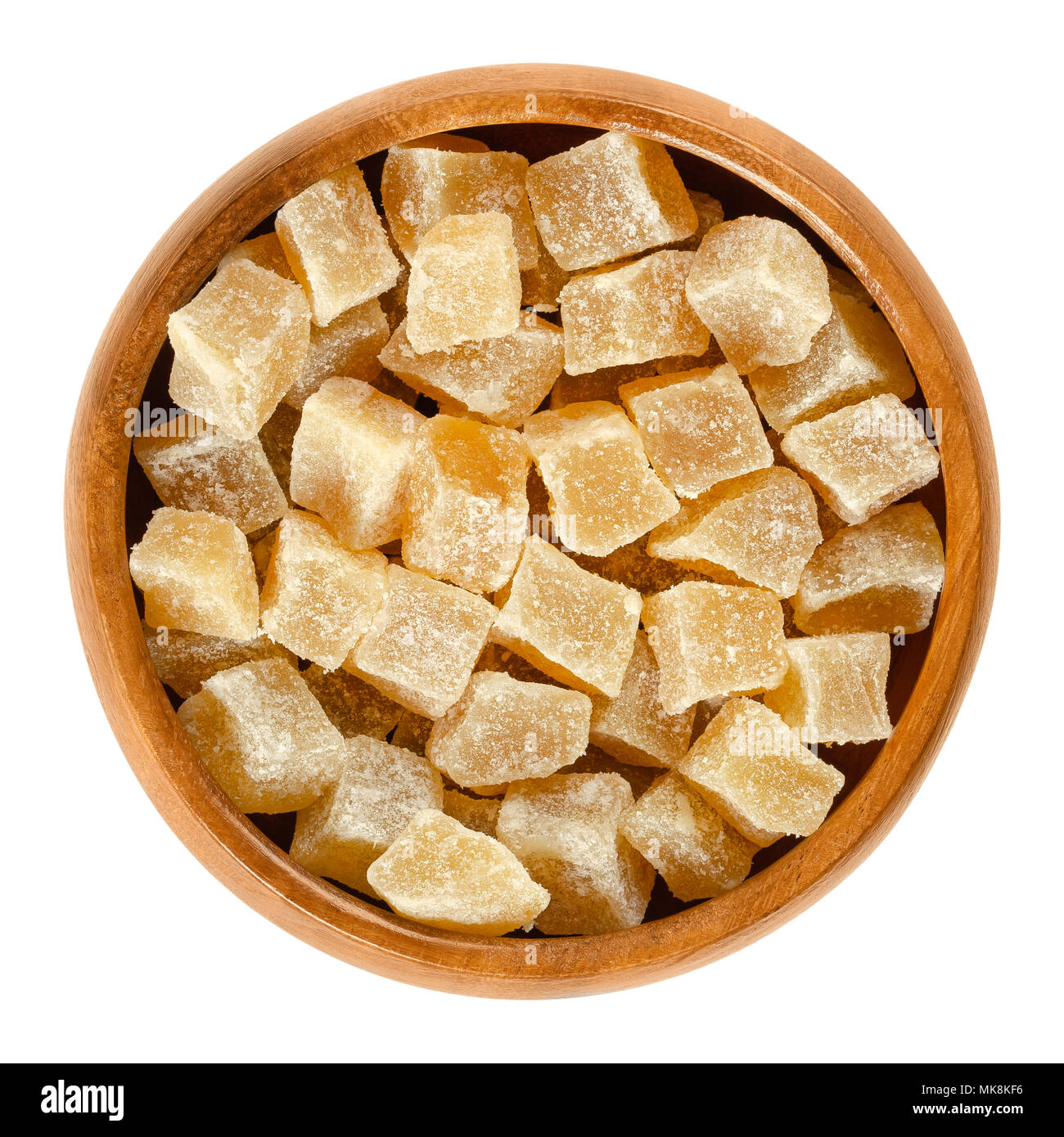 I canditi di radice di zenzero cubi nella ciotola di legno. Cristallizzato radici di Zingiber officinale. Colore arancio rizomi, conservate con zucchero. Snack. Foto Stock