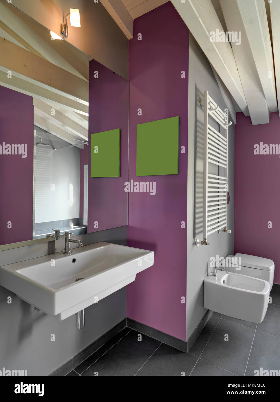 Scatti di interni di un moderno bagno in camera attico in primo piano hte il built-in lavandino le pareti sono dipinte di viola Foto Stock
