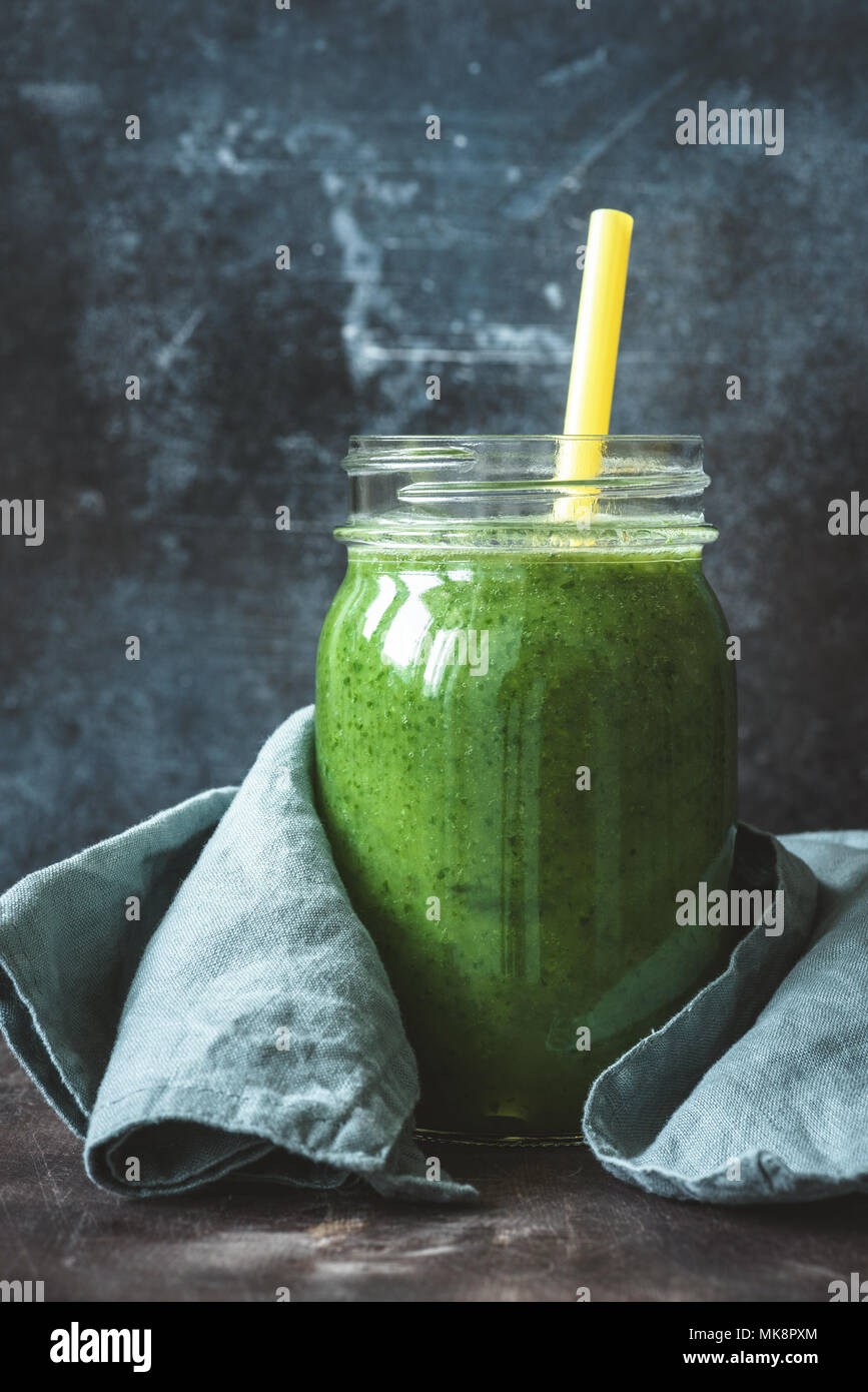 Detox smoothie verde in bottiglia di vetro con una cannuccia. Cavolo verde di spinaci frullato. Bottiglia frullato. Pulizia, detox, dieta, fitness, vita sana Foto Stock