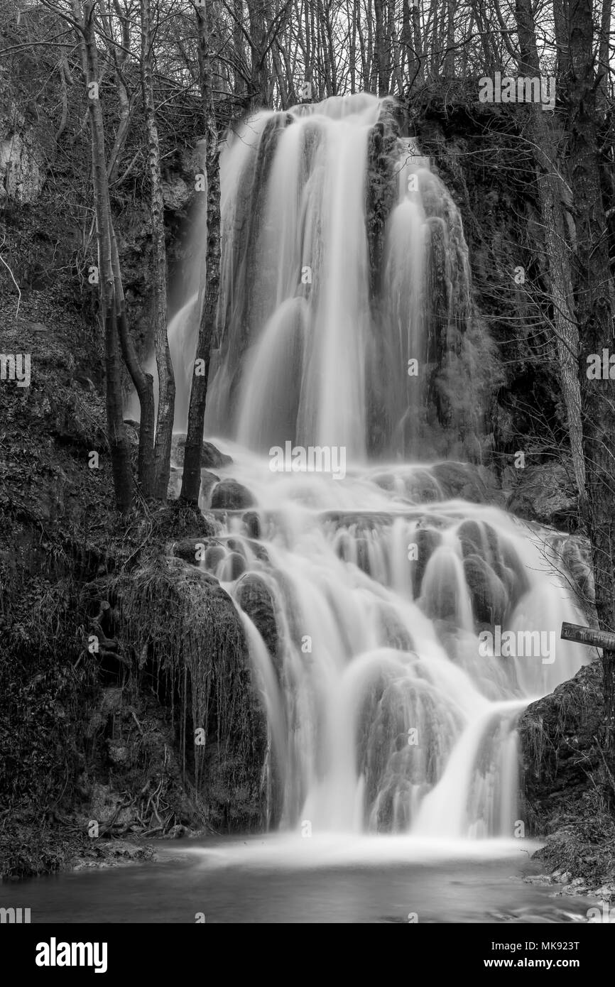 Bella cascata serbo tempo di esposizione lungo la fotografia, moto ad acqua in bianco e nero. Inverno close-up immagine Foto Stock