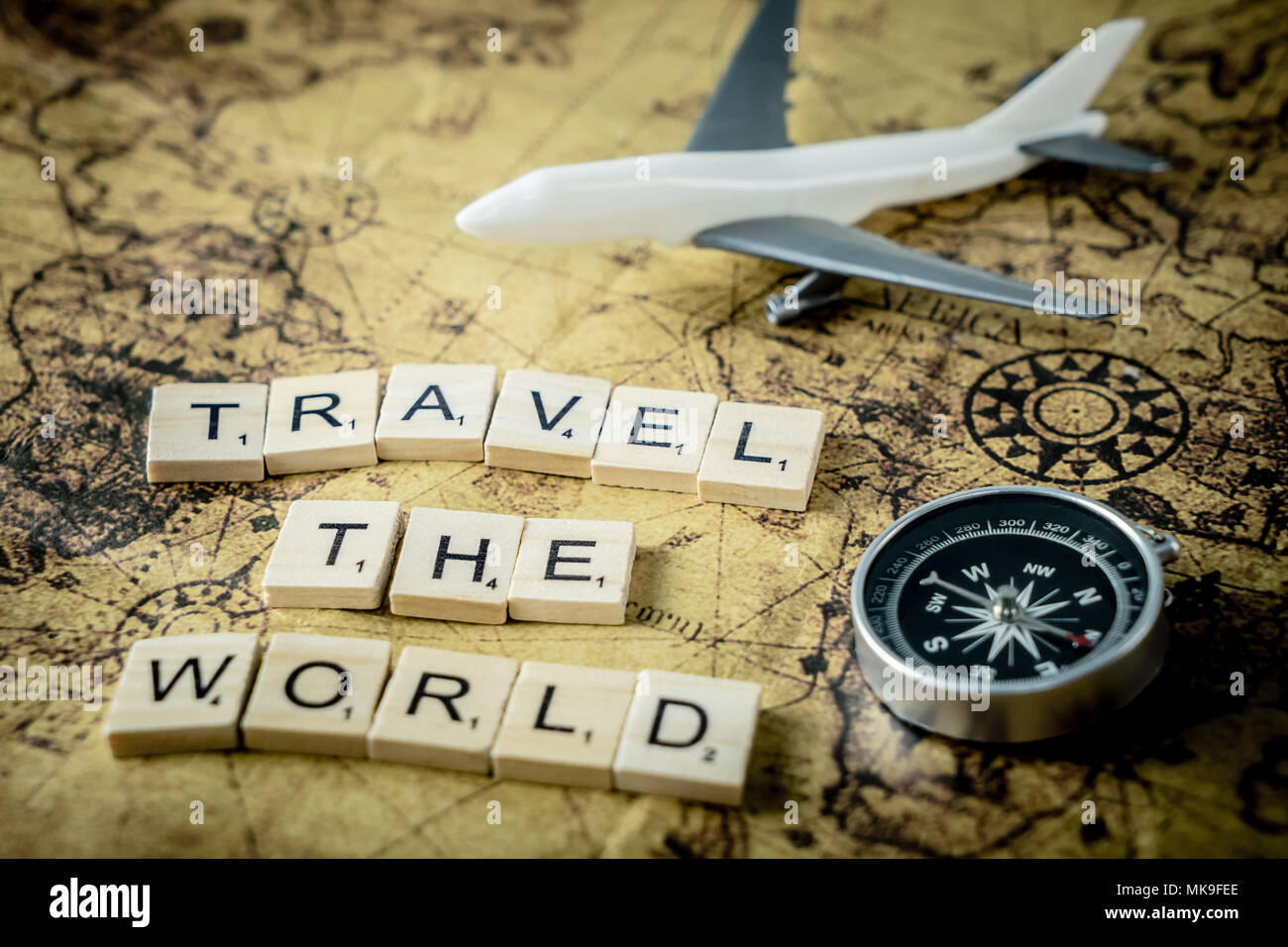 Viaggiare per il mondo il concetto di testo di Scrabble e apparecchiature di viaggiatori su vintage map Foto Stock