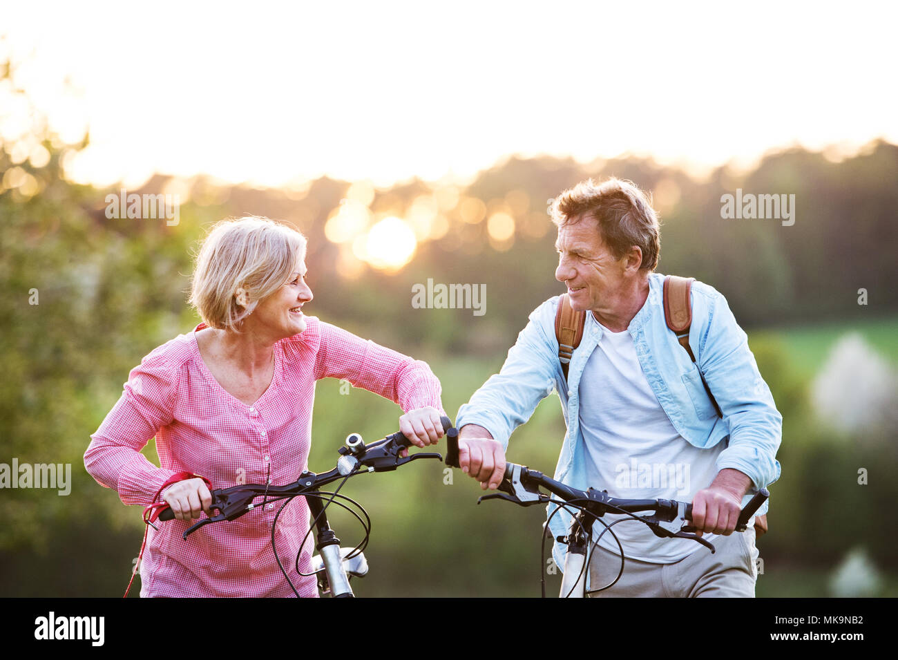 Bella coppia senior con le biciclette al di fuori in primavera la natura. Foto Stock