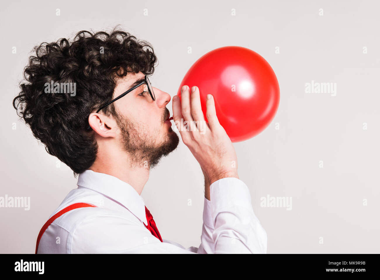 Ritratto di un giovane uomo con palloncino in un monolocale. Foto Stock