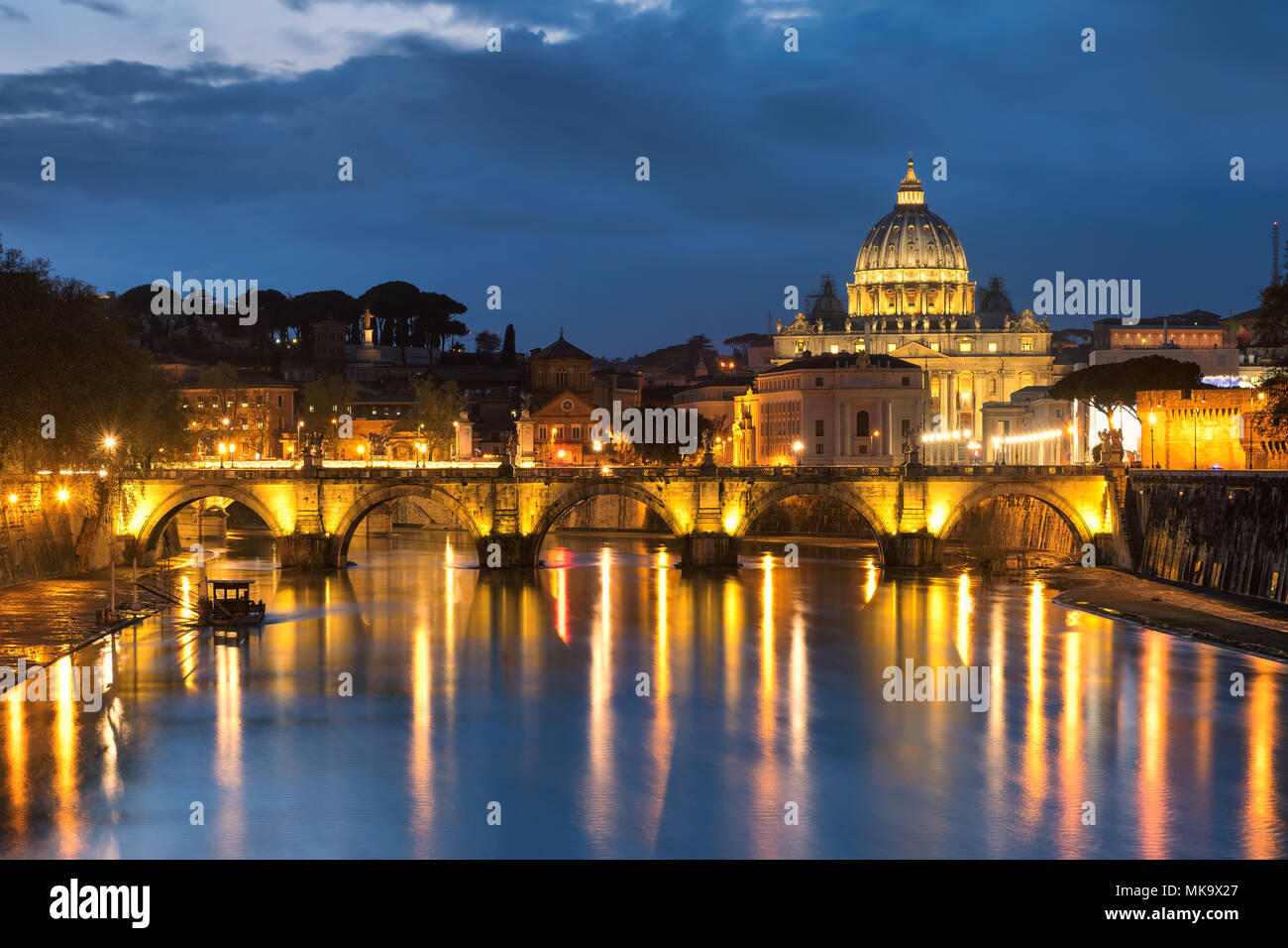 Vista notturna al Tevere e la cattedrale di San Pietro a Roma, Italia. Foto Stock