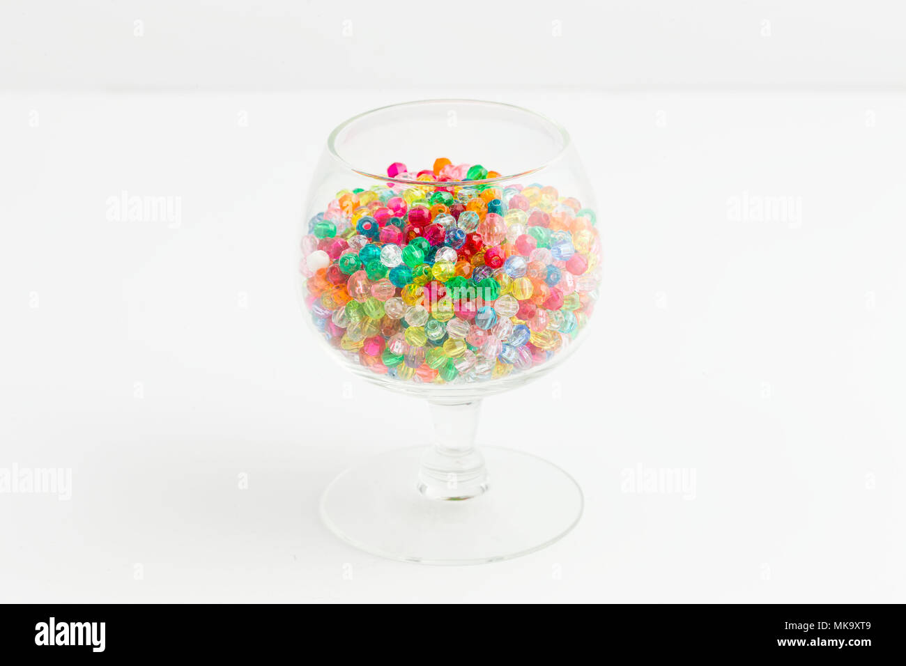 Un bicchiere di minuscoli multicolori perline utilizzate per creare gioielli Foto Stock