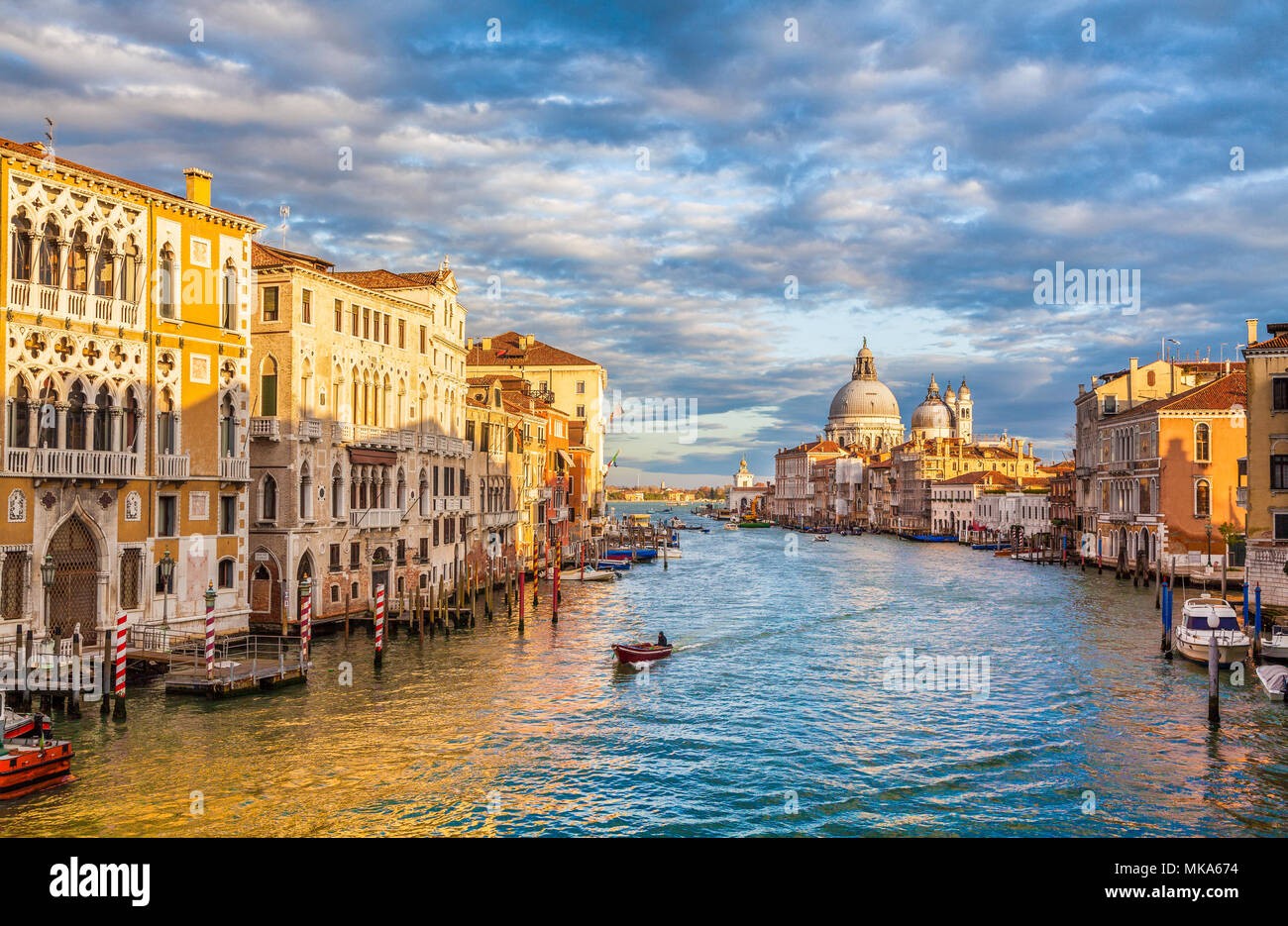 Classic vista panoramica del famoso Canal Grande con scenic Basilica di Santa Maria della Salute in beautiful Golden luce della sera al tramonto, Venezia Foto Stock