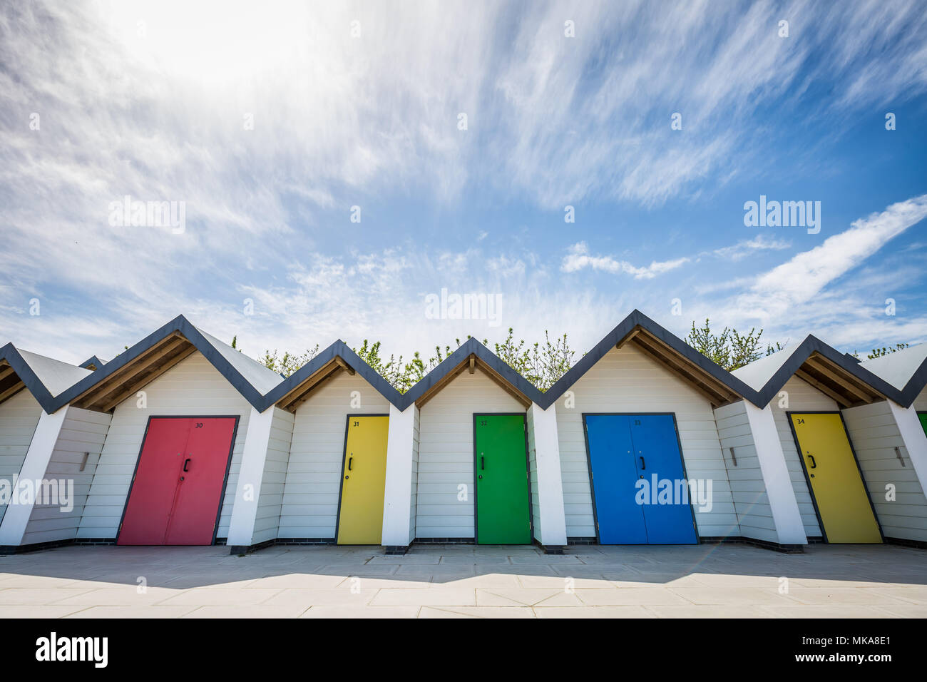 Pittoresca spiaggia di capanne stare vicino alla riva in un caldo pomeriggio assolato nella città costiera di Swanage, Dorset, Regno Unito. Foto Stock