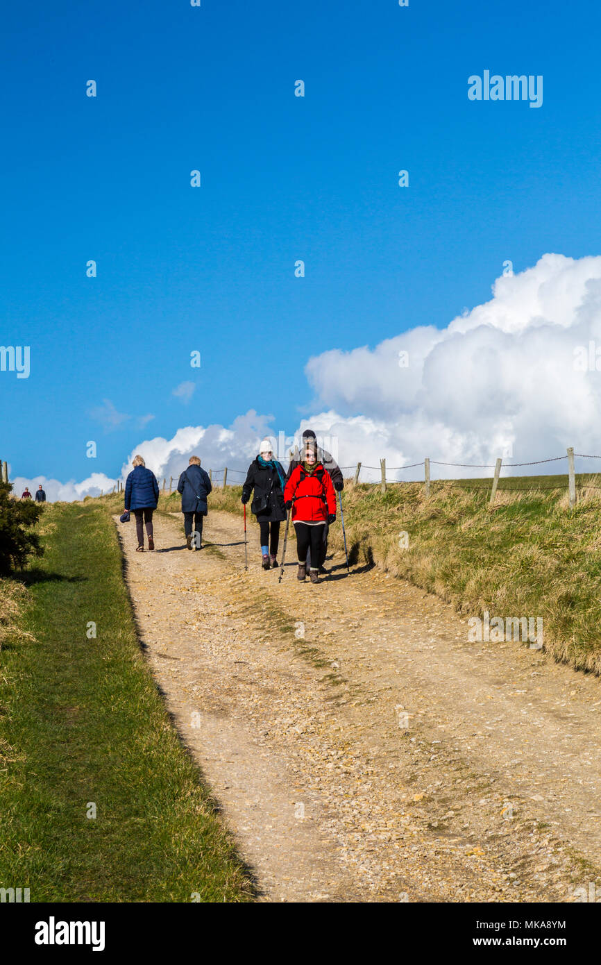 Walkers su una pista da Ringstead Bay al bianco noil punto della Jurassic Coast Path. Il Dorset, England, Regno Unito Foto Stock
