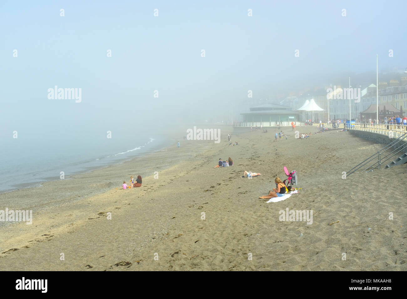 Aberystwyth, Wales, Regno Unito. 7 maggio 2018. Un persistente sea-nebbia mantiene il sole a bay in Aberystwyth, ma che non smette di alcune persone di godersi la spiaggia. Credito: Alan Hale/Alamy Live News Foto Stock
