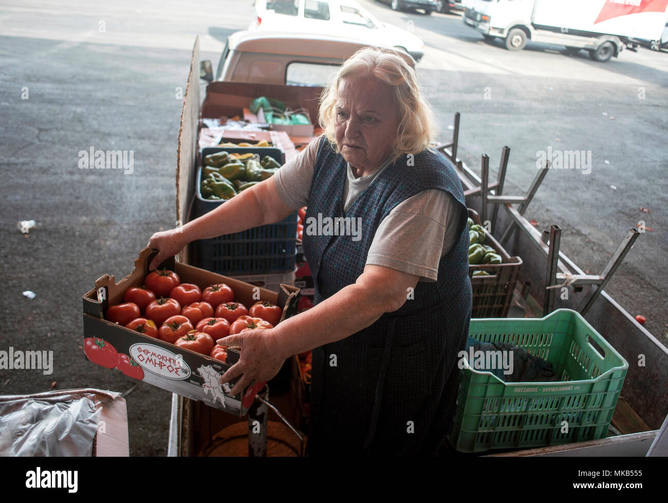 A 73 anni carichi di donna il suo veicolo con casse di Ortaggi Frutta & Verdura in Atene, Grecia. ©Elias Verdi/Alamy Stock Foto Foto Stock