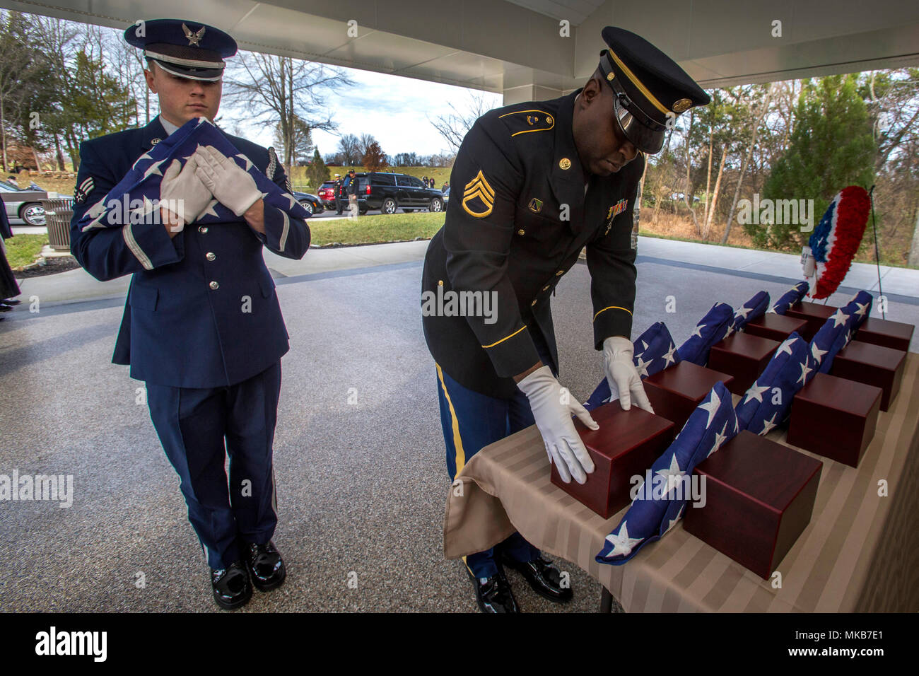 Stati Uniti Il personale dell'esercito Sgt. Asim Williams, destra posiziona un urna contenente l'cremains di un veterano mentre Senior Airman Joshua Kaemmer, entrambi membri del Brigadiere Generale William C. Doyle Memorial Cemetery Guardia d'onore, attende per posizionare una bandiera americana di fronte ad esso durante la ventiseiesima New Jersey missione di onore cerimonia presso il Cimitero di North Hanover Township, N.J., nov. 30, 2017. Il cremains di una guerra mondiale - veterano John J. Aron, sette II Guerra Mondiale Veterani - Leslie H. Allen, Louis J. Bakelaar, Gilbert C. Johnson, Theodore Martin, Robert W. Milner, James K. Molony e Edith L. Sherwood, e Foto Stock