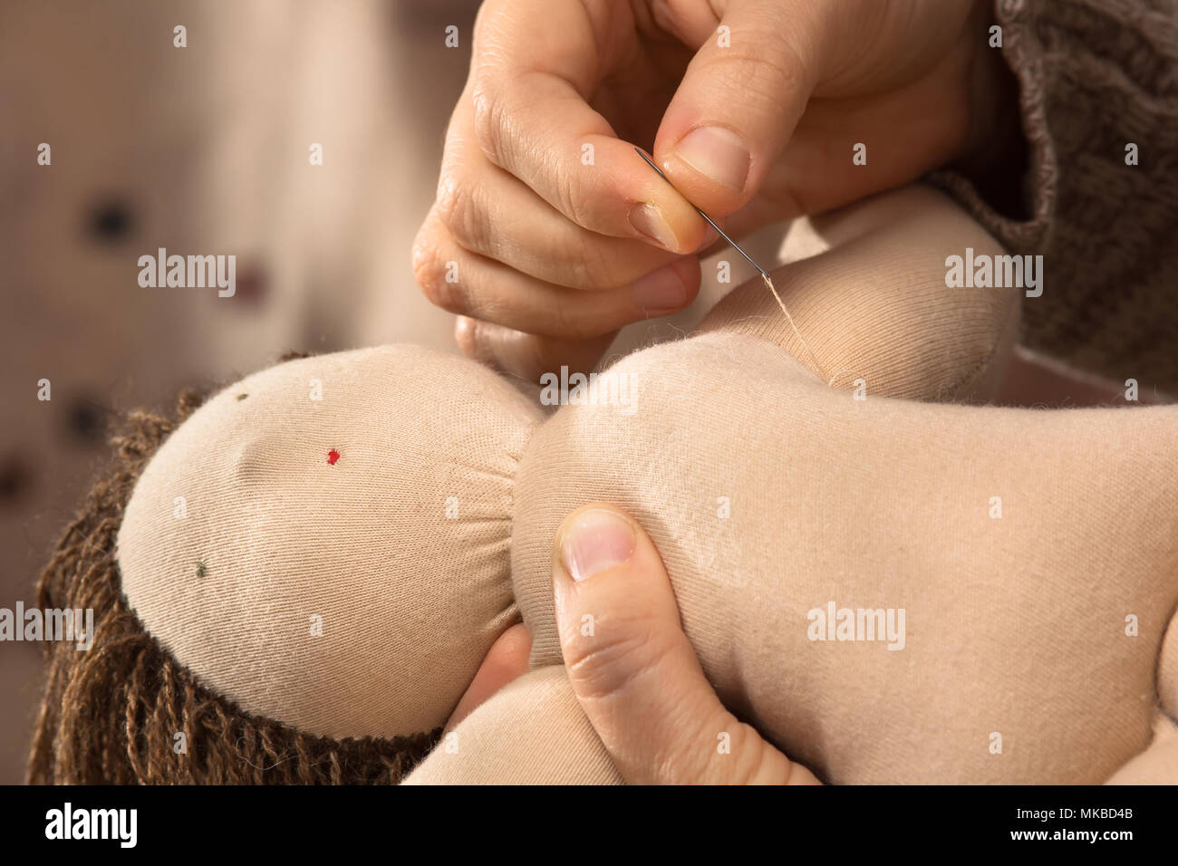 Le mani della donna la cucitura di una bambola Waldorf Foto Stock