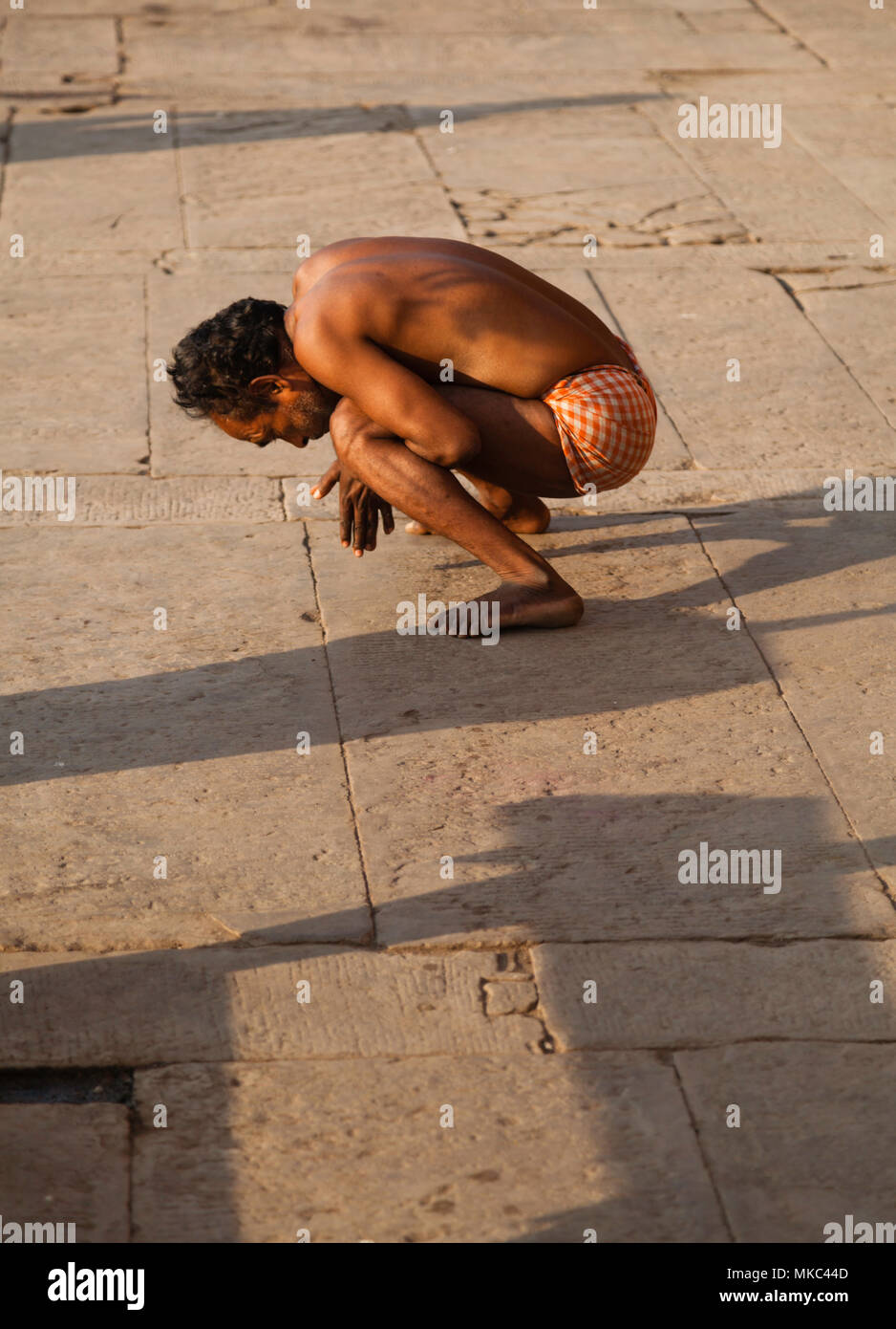 Sulle rive del fiume Gange a Varanasi centinaia di persone può essere visto fare yoga come esercizio, questo signore era solo uno dei molti partecipanti Foto Stock