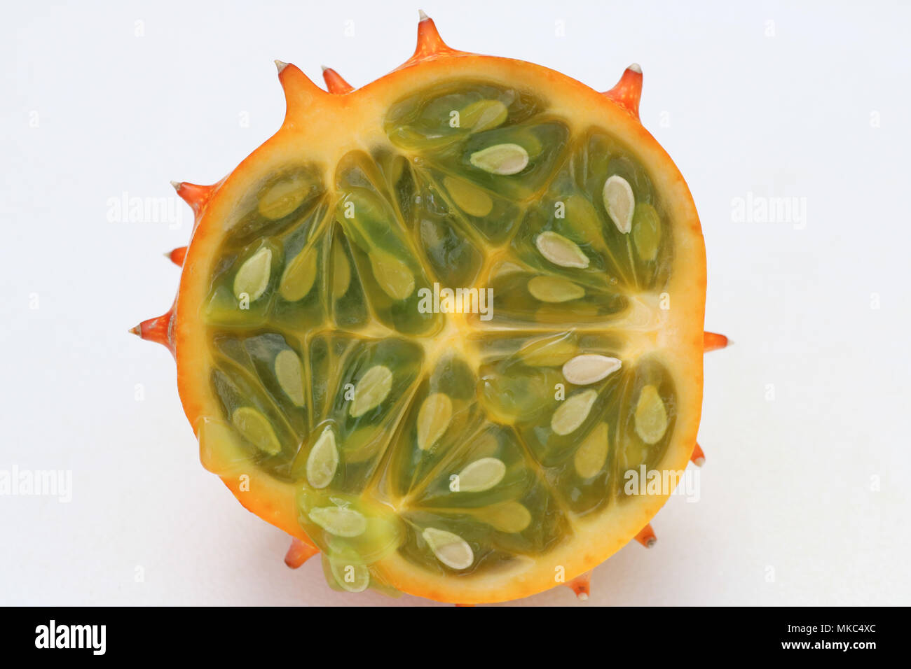 Primo piano della kiwano cornuto melone tagliato a metà contro uno sfondo bianco Foto Stock
