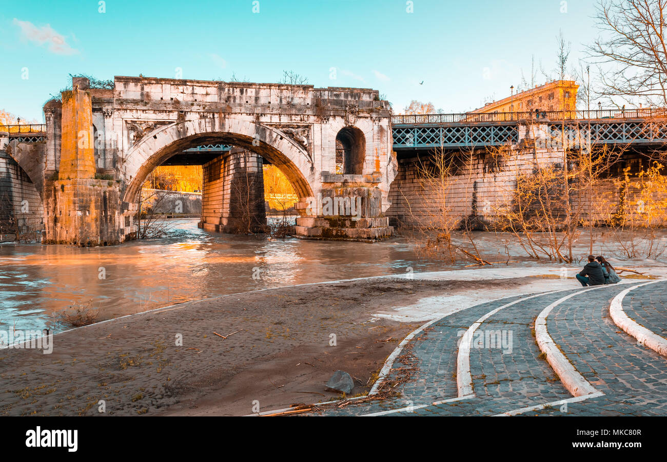 L antico ponte Emilio chiamato Ponte Rotto,il più antico ponte in muratura a Roma, sul fiume Tevere di fronte all'Isola Tiberina con due amanti cercando Foto Stock