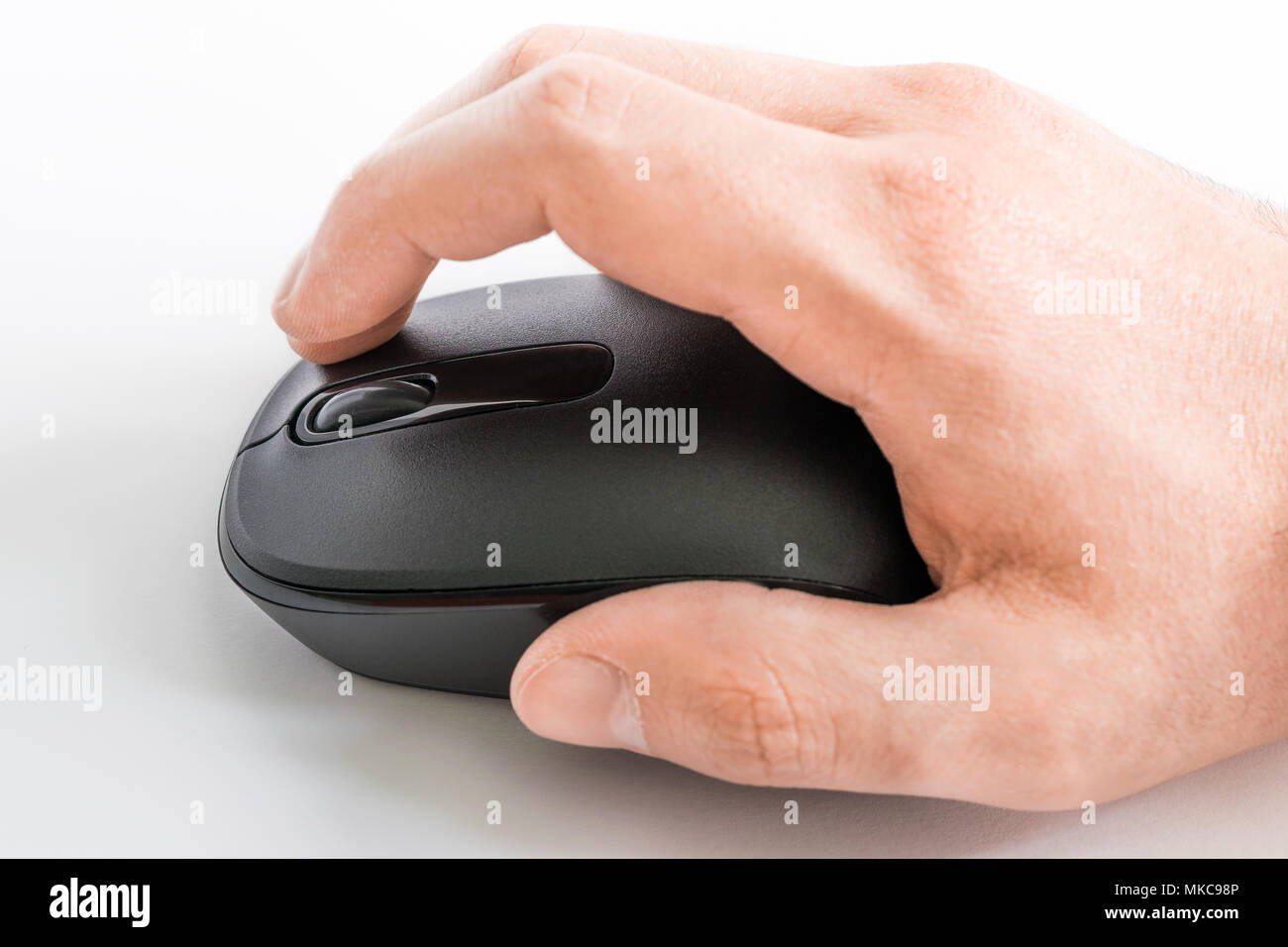 Una mano che utilizza un mouse per computer su sfondo bianco Foto Stock