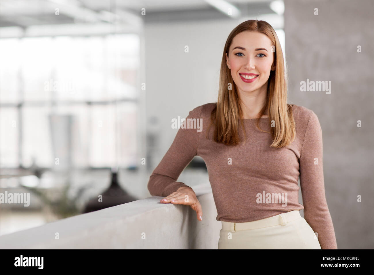 Felice imprenditrice sorridente in ufficio Foto Stock