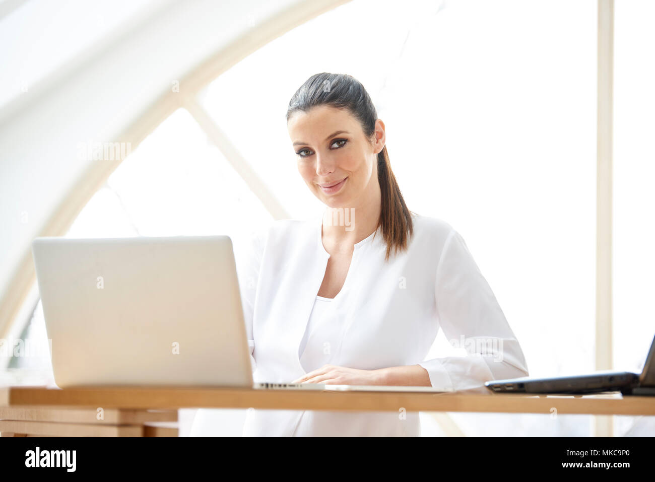 Ritratto di giovane attraente assistente vendite imprenditrice utilizzando computer portatile presso l'ufficio. Foto Stock