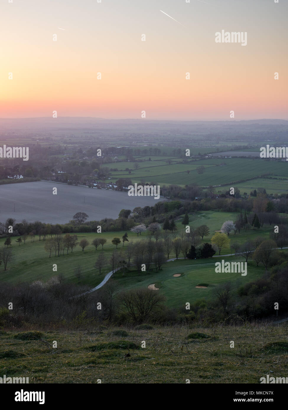 Il sole tramonta su campi e villaggi nel paesaggio agricolo del Aylesbury Vale, visto dal Combe Hill sulla scarpata del Chiltern Hills. Foto Stock