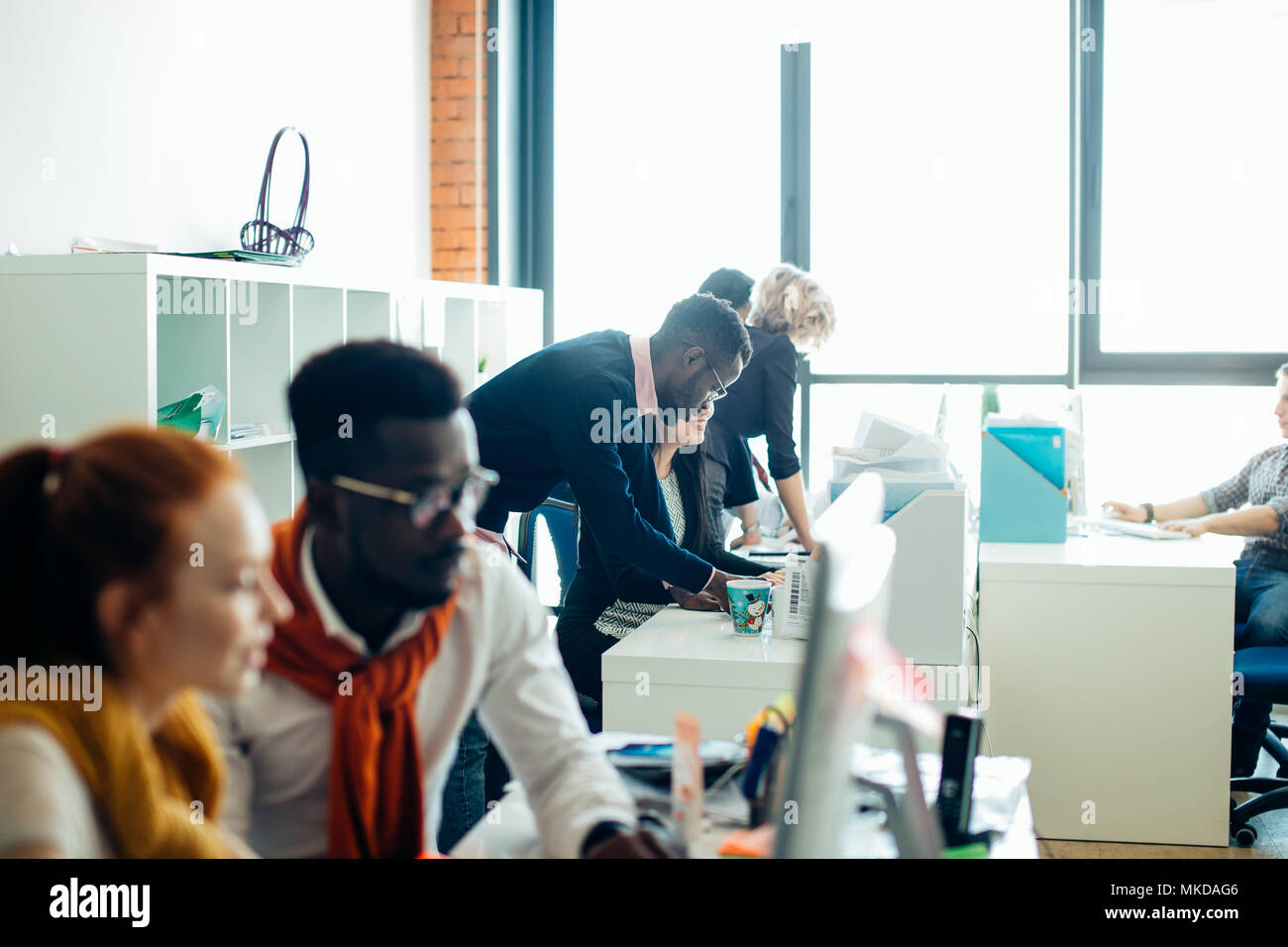 Giovani multi razziale economisti sono di studiare le statistiche in ufficio bianco con finestra panoramica Foto Stock