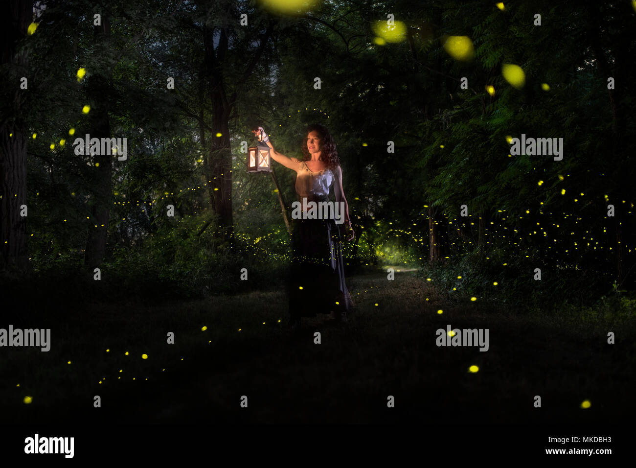 Una ragazza sta cercando le lucciole su una foresta vicino al fiume Po in Italia Foto Stock