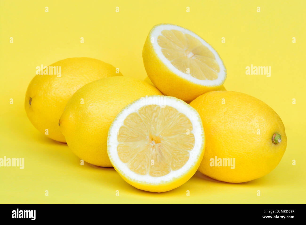 Cumulo di limone fresco su sfondo giallo Foto Stock