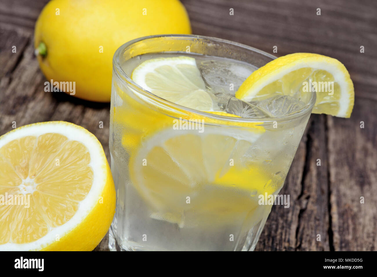 Un bicchiere di acqua fresca con un limone sul tavolo di legno Foto Stock