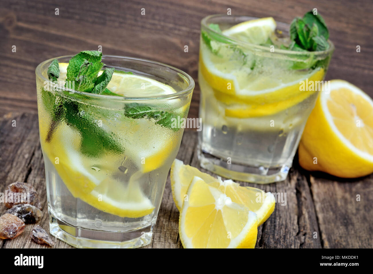 Acqua fresca con limone e menta su uno sfondo di legno vicino fino Foto Stock
