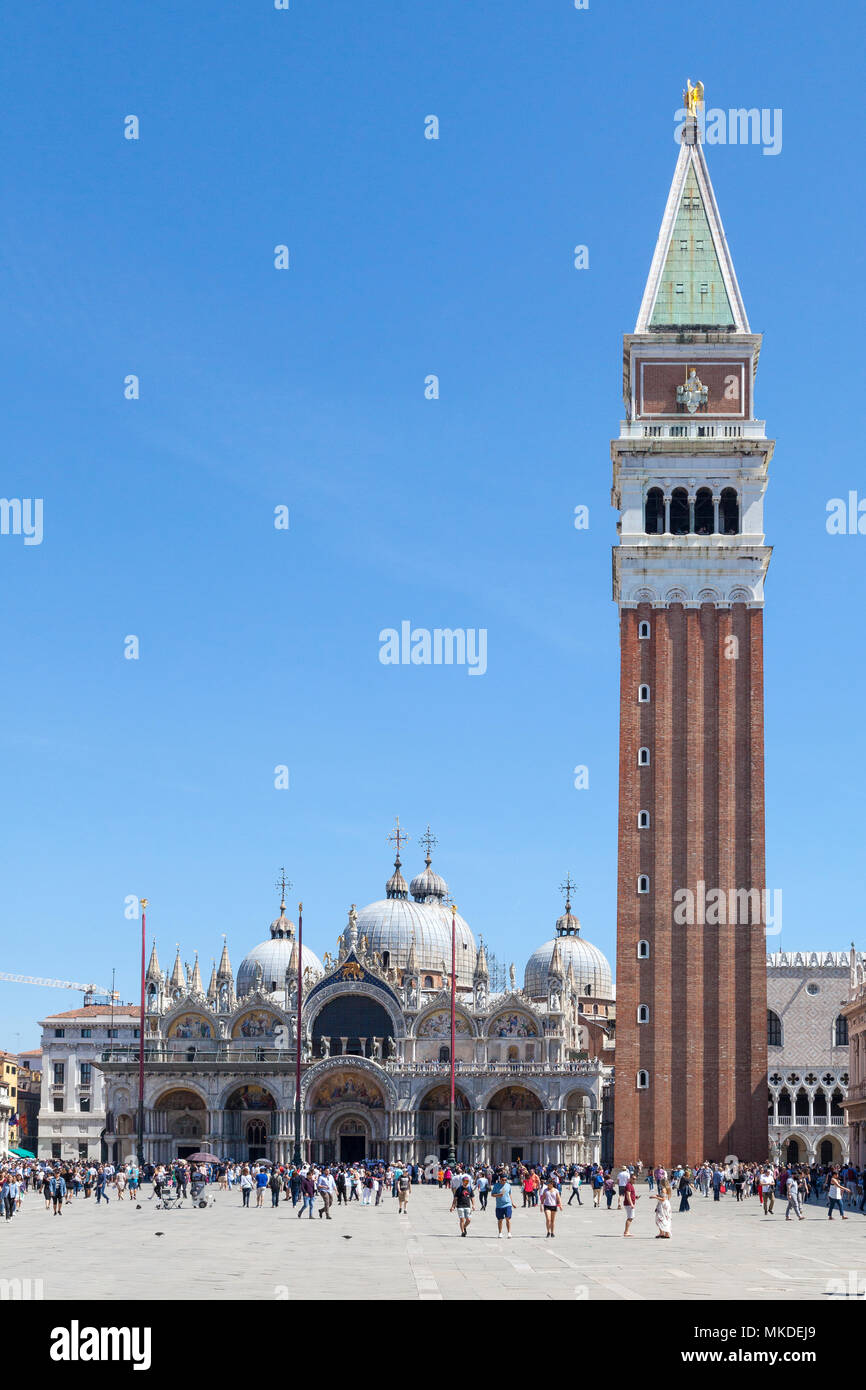 I turisti in giro per Piazza San Marco (Piazza San Marco), Venezia, Veneto, Italia nella parte anteriore del St Marks Cattedrale (Basilca San Marco) e il Campanile Foto Stock