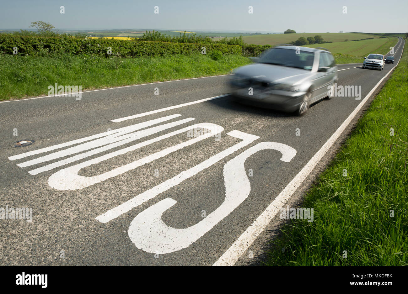 Un segno lento sul ciglio di una collina su una strada attraverso la campagna di Dorset che conduce nella distanza al Dorchester Dorset in Inghilterra England Regno Unito. Il 7 maggio 2018 Foto Stock