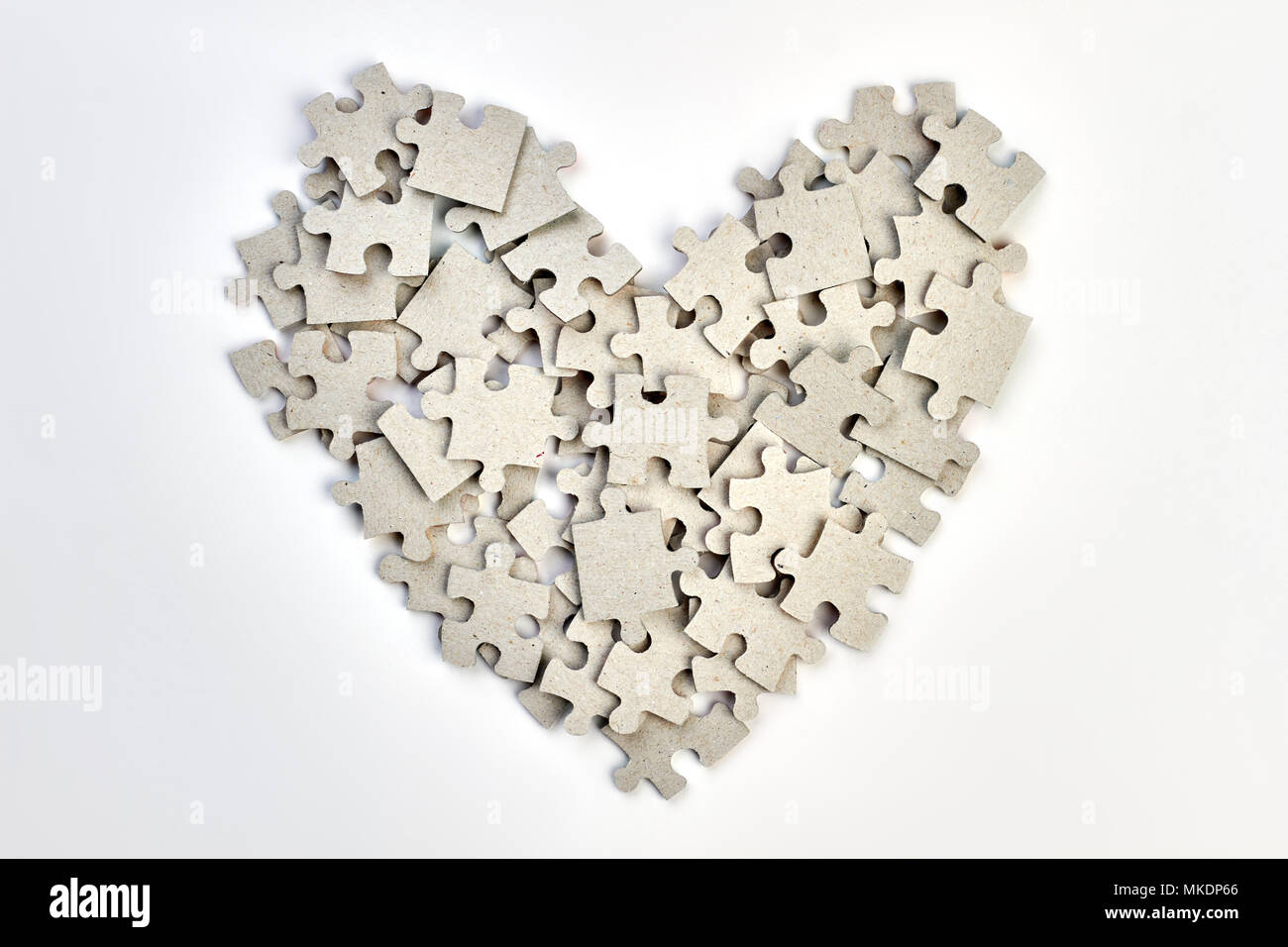 Cuore realizzato da puzzle. Forma di cuore fatta da pezzi di puzzle su  sfondo bianco Foto stock - Alamy