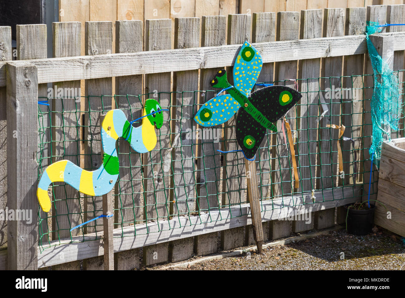 Animali colorati su una recinzione di legno. Impostazione scuola o vivaio Foto Stock