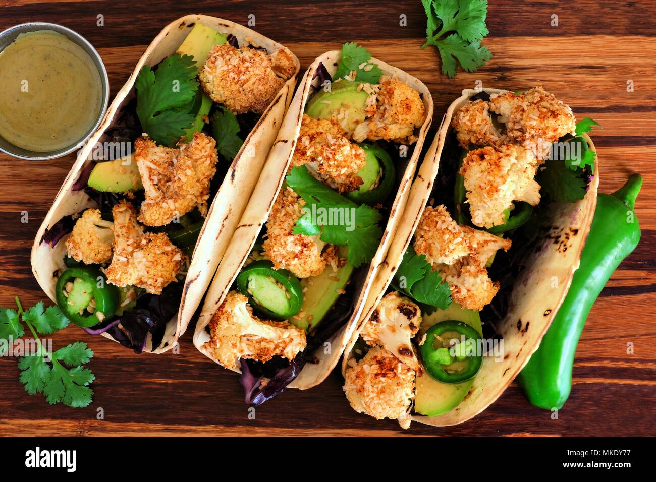 Arrosto di cavolfiore noce di cocco tacos. Sana, pasto vegano. Vista dall'alto su un sfondo di legno. Foto Stock