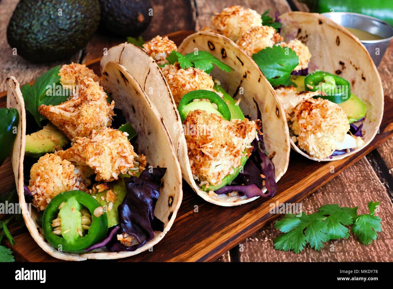Arrosto di cavolfiore noce di cocco tacos. Sana, pasto vegano. Close up, vista laterale su un sfondo di legno. Foto Stock