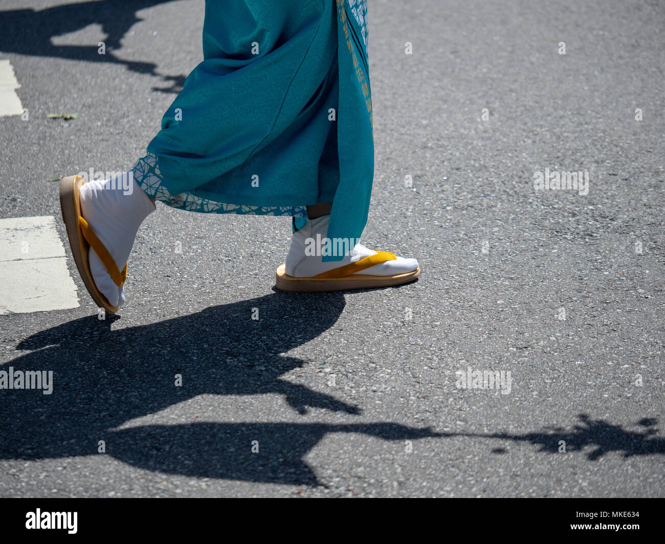 Donna che indossa festoso dei tabi giapponese calze con sandali marching all'aperto Foto Stock