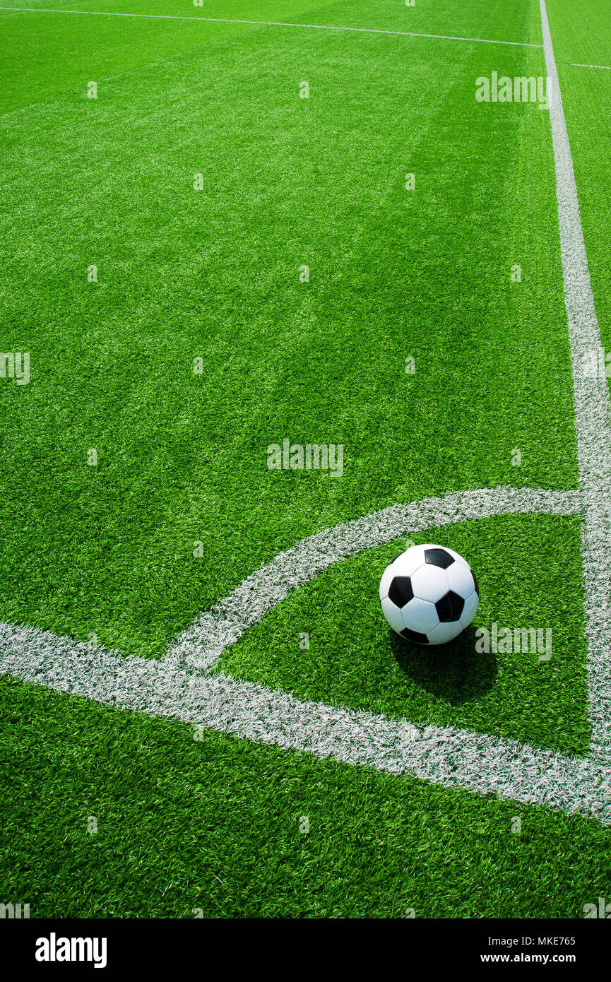 Pallone da calcio classico bianco e nero su verde erba artificiale dal punto ad angolo Foto Stock