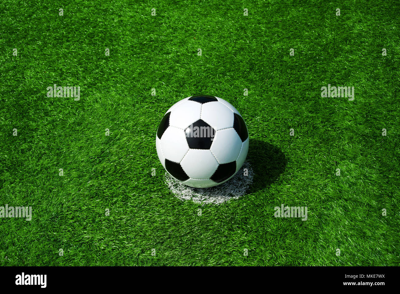 Pallone da calcio classico bianco e nero sulla pena di macchia verde erba artificiale Foto Stock