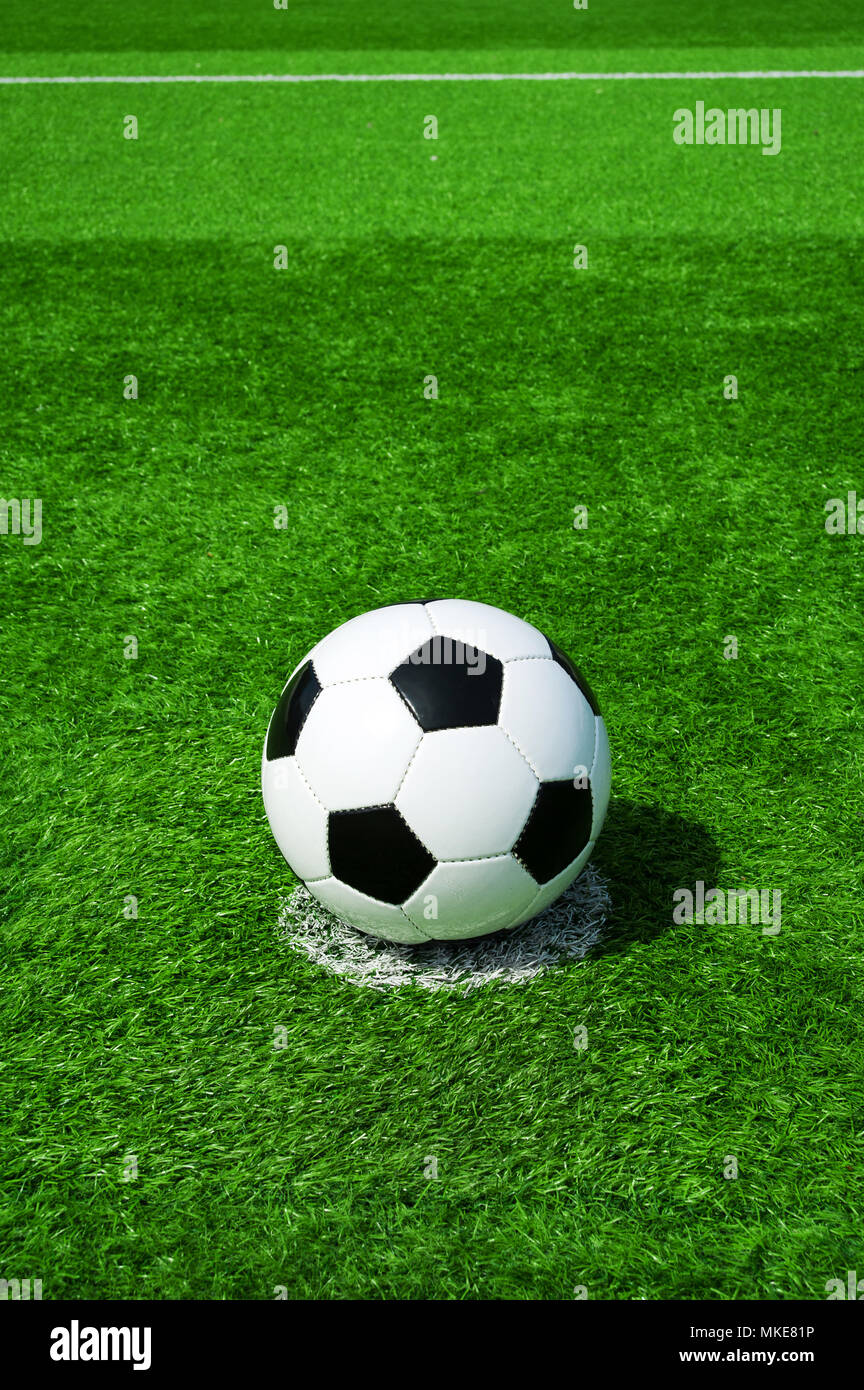 Pallone da calcio classico bianco e nero sulla pena di macchia verde erba artificiale Foto Stock