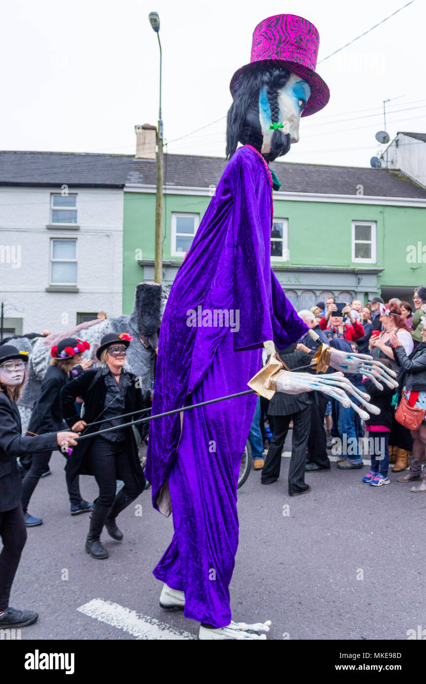 Colorati pupazzi giganti di prendere parte a una processione di strada festeggia un annuale jazz festival di Ballydehob, Irlanda. Foto Stock