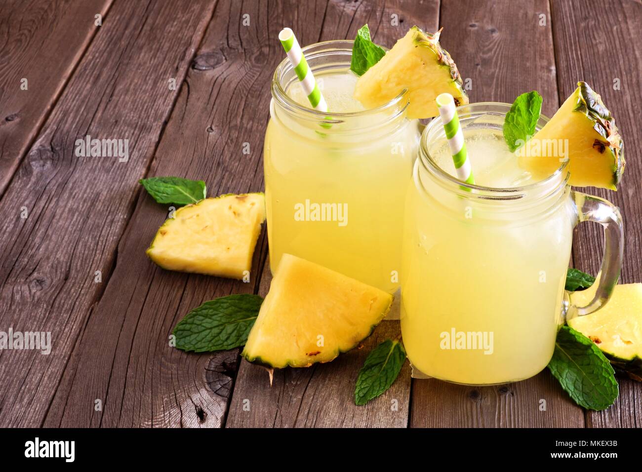Succo di ananas a mason jar occhiali su un rustico sfondo legno Foto Stock