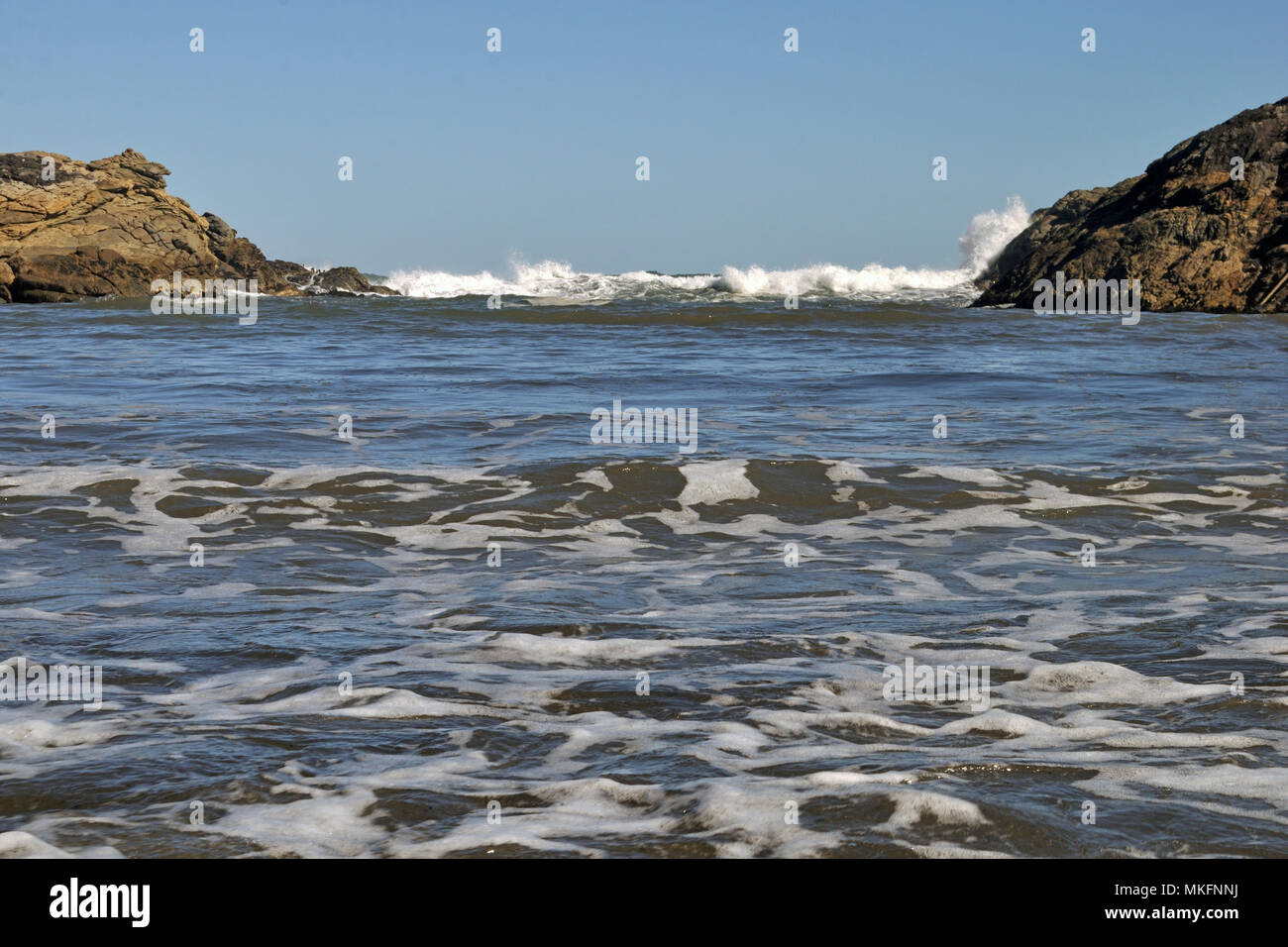 Le onde in arrivo invadere costante Bay sulla costa ovest della Nuova Zelanda Foto Stock