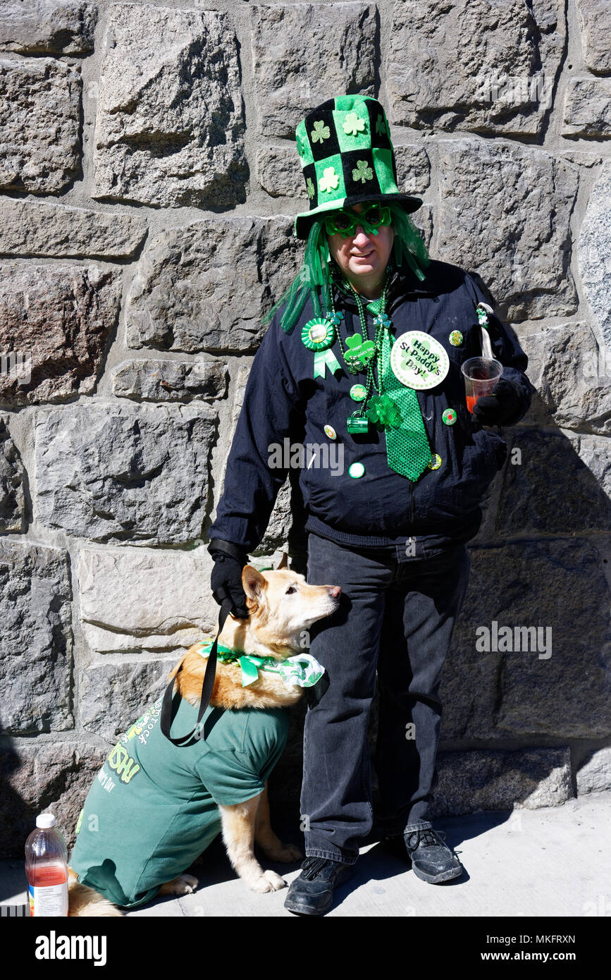 Un uomo e il suo cane, sia indossando il verde per Montreal il giorno di San Patrizio parade Foto Stock