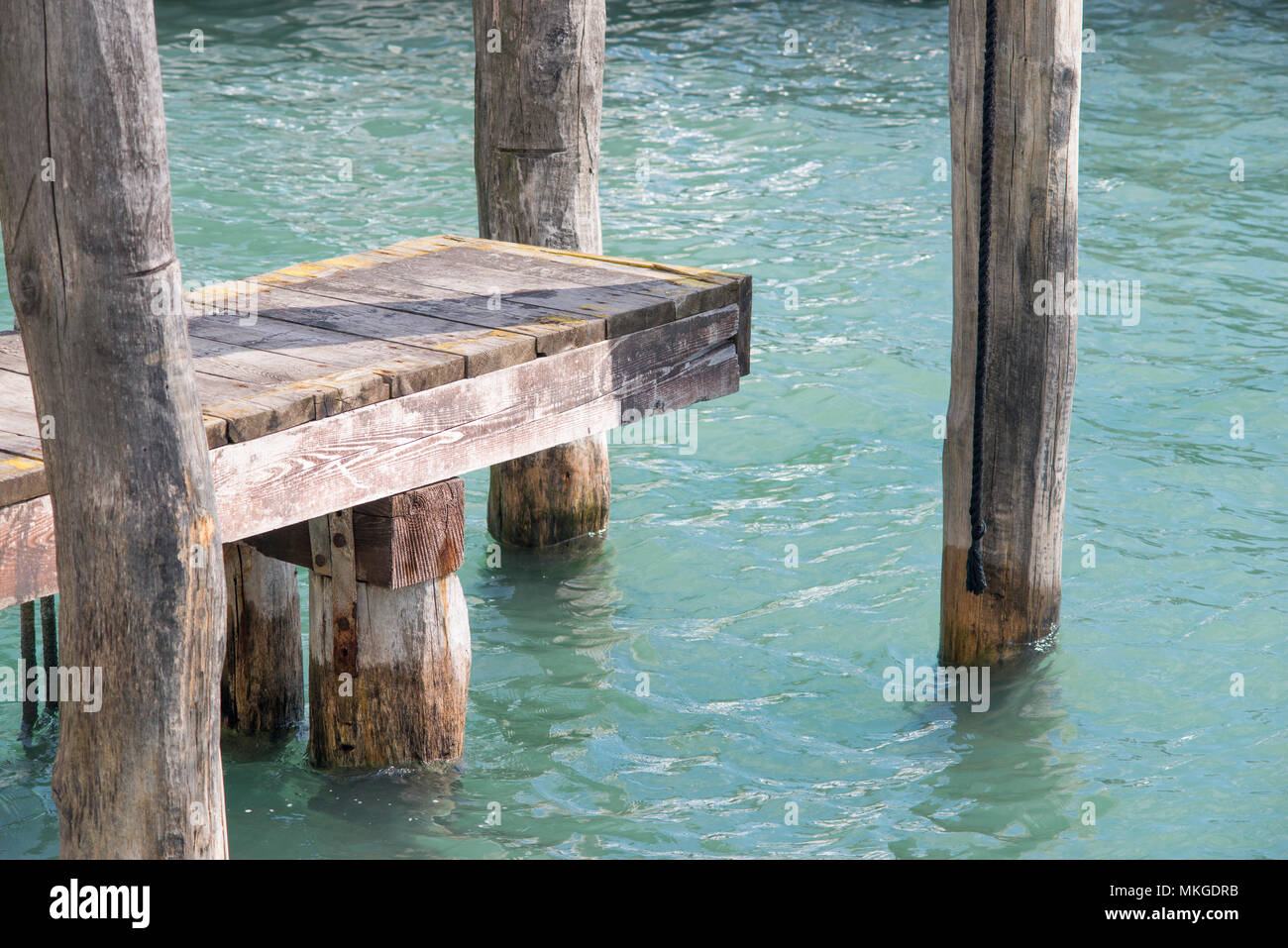 Massiccio di legno ruvido pier nel canale di acqua della città di Venezia, Italia Foto Stock