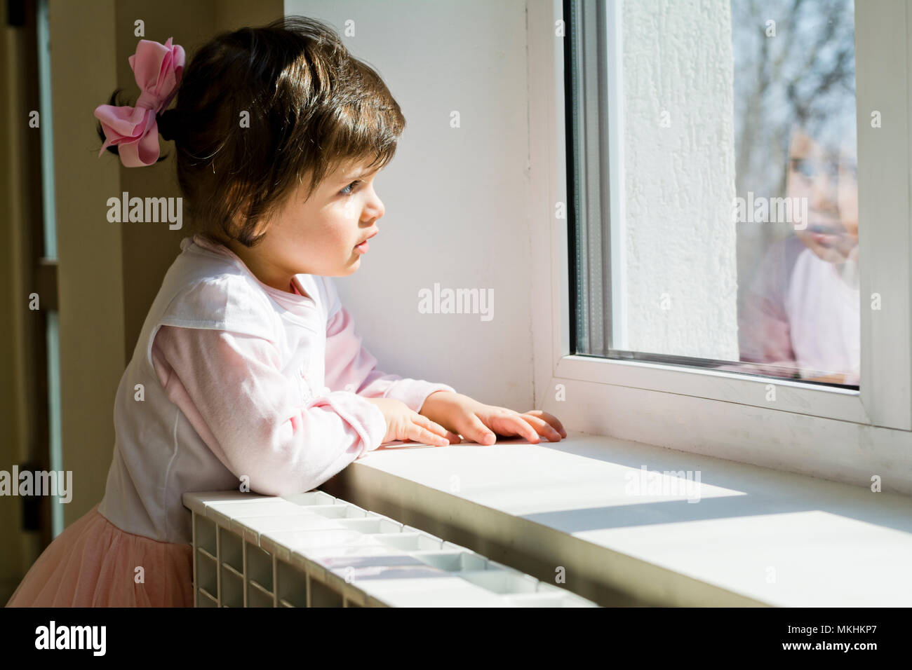 Ragazza in attesa in corrispondenza della finestra Foto Stock