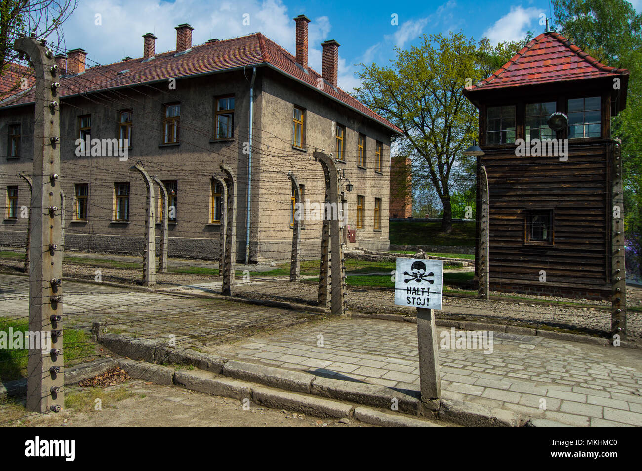 'Halt stoj!", il segnale di arresto con cranio in Auschwitz, campo di concentramento nazista della Polonia. Il paesaggio durante una giornata di sole con edifici in background. Foto Stock