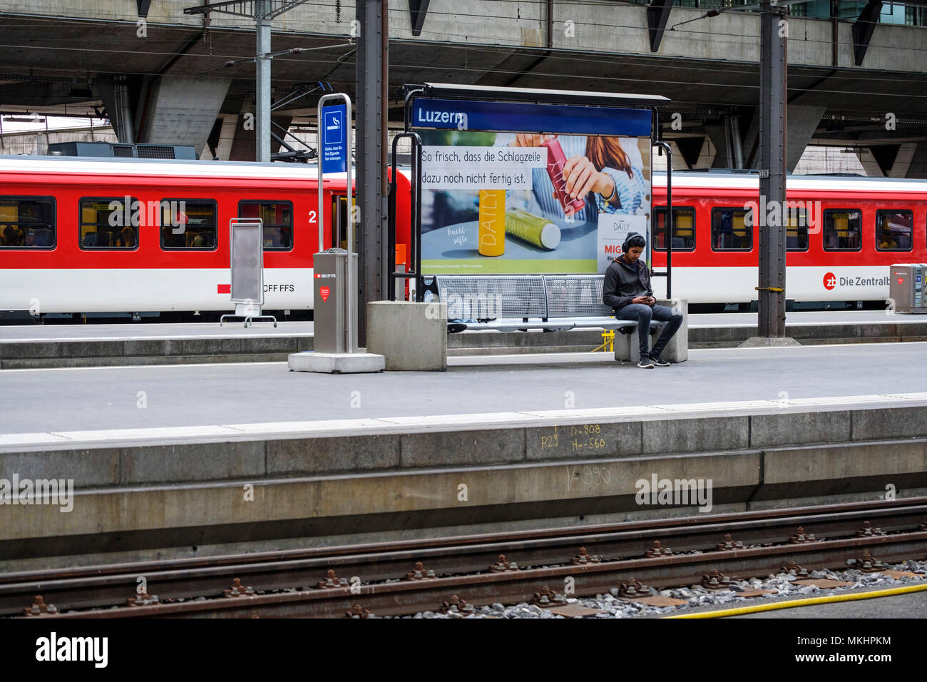 Uomo in attesa del treno per arrivare alla stazione centrale di Lucerna, Lucerna, Svizzera, Europa Foto Stock