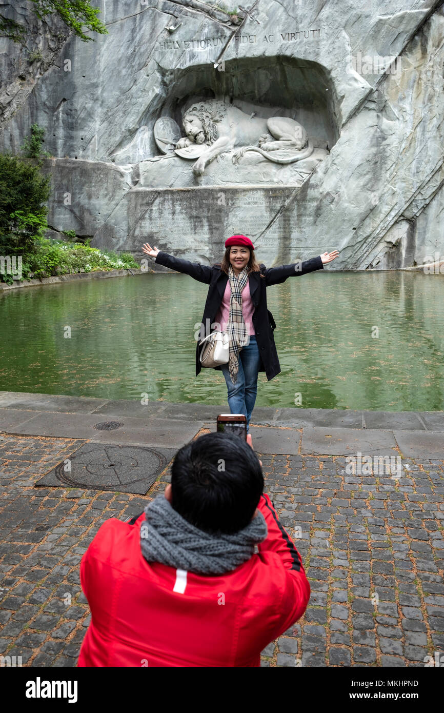 I turisti a scattare foto con lo smartphone nella parte anteriore del morente il Monumento del Leone a Lucerna, Svizzera, Europa Foto Stock